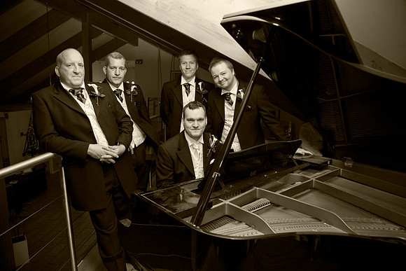 Groom and Groom's Men at a piano after the wedding